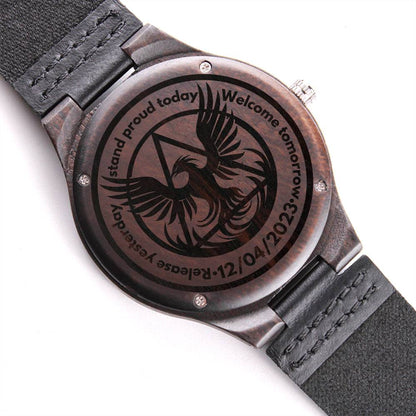 Engraved wood watch with dark round case and black leather strap, phoenix engraved dial.