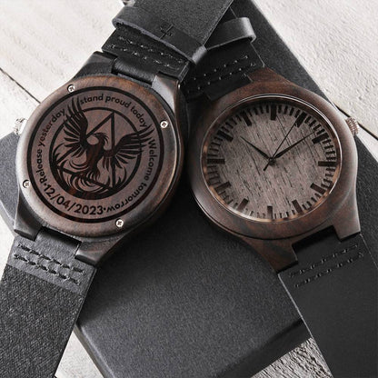 Engraved wood watch with dark round case, black leather strap, phoenix engraved dial.