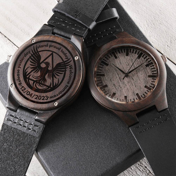 Engraved wood watch with dark round case, black leather strap, phoenix engraved dial.