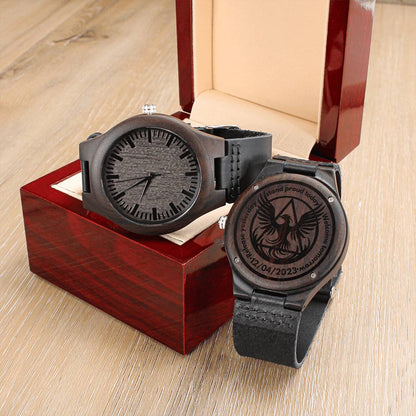 Two wood watches displayed in red and beige gift boxes, dark round cases, black leather bands.