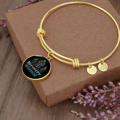 Gold bangle bracelet with round warrior emblem charm and small USA-made tags