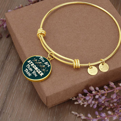 Gold round charm with “Your Text Here” engraved, on a bail and loop