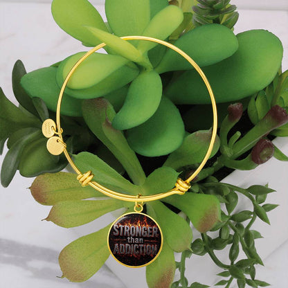 Gold bangle bracelet with round black statement charm and engraved disc accents