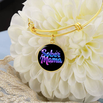 Gold bangle bracelet with round “Sober Mama” charm pendant