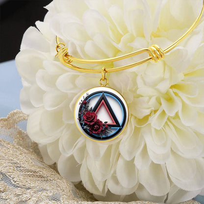 Gold bangle bracelet with round recovery symbol charm featuring red rose detail