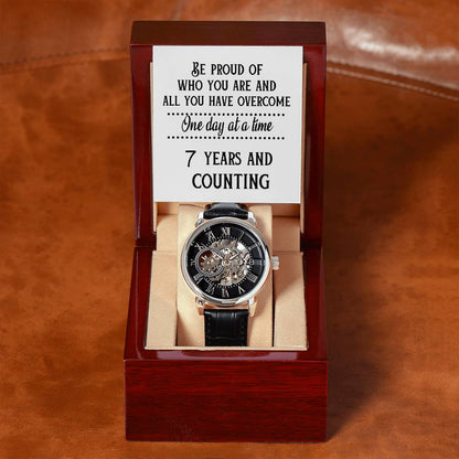 Mechanical openwork watch with black leather strap in burgundy display box.