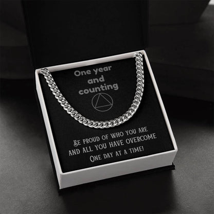 Silver-tone chain necklace laid across a gift box
