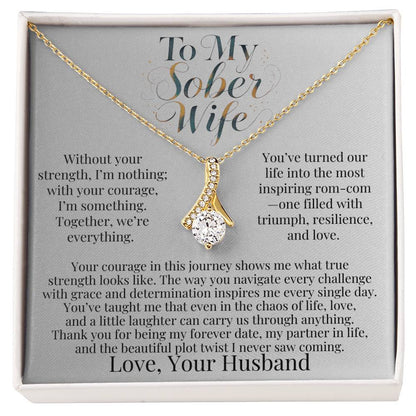 Gold-tone teardrop pendant necklace with faceted stone on a chain