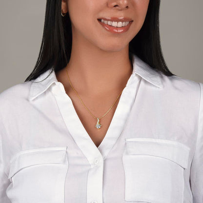 Gold-tone necklace with teardrop pendant, worn on a white button-up shirt