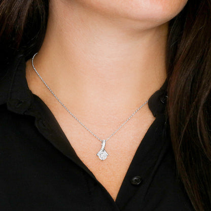 Silver-tone pendant necklace on neck, teardrop charm with clear stones
