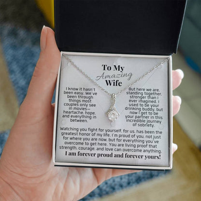Silver-tone pendant necklace in small gift box held in hand, teardrop charm