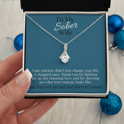 Silver-toned teardrop pendant necklace on a chain in a gift box.