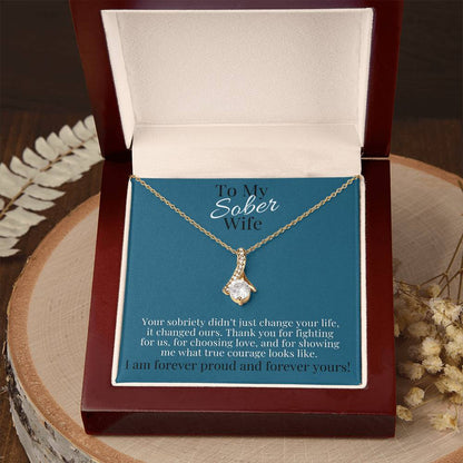 Gold-toned teardrop pendant necklace on a chain in a gift box.