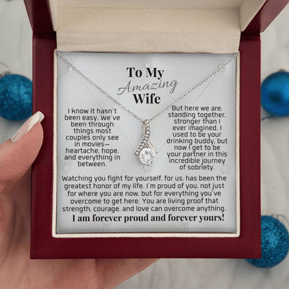 Necklace with silver-toned chain and small heart charm on a gift card.