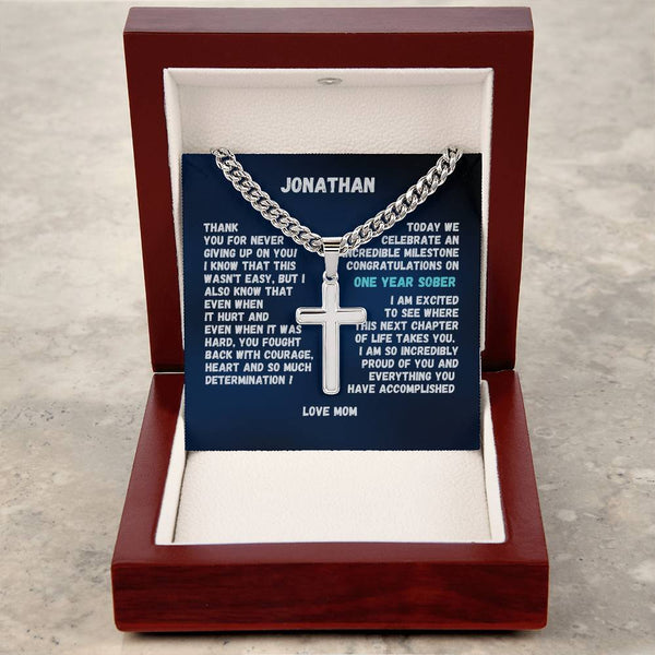 Silver cross pendant necklace with name plate in brown gift box, chain draped on blue card