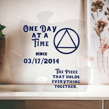 Acrylic puzzle-shaped display with blue quote text and triangle emblem