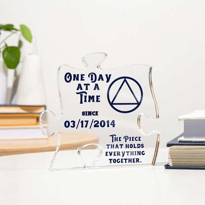 Clear acrylic puzzle display with blue quote text, triangle emblem, and jigsaw-style shape
