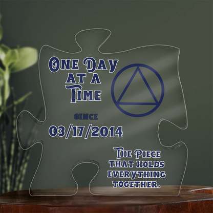 Acrylic puzzle-shaped display with blue quote text and triangle emblem on clear pieces