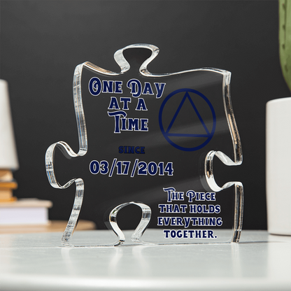 Clear acrylic puzzle display with blue quote text and triangle emblem, front view