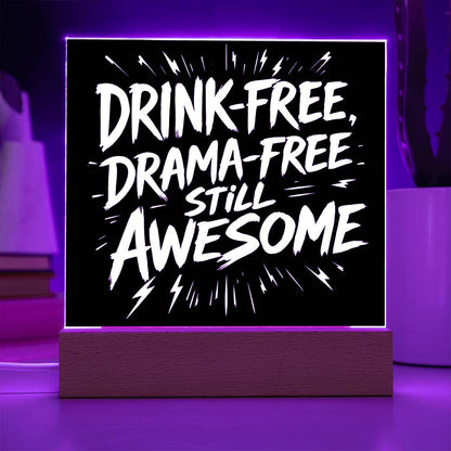 LED plaque with black panel and white slogan DRINK-FREE, DRAMA-FREE, STILL AWESOME, purple-lit frame