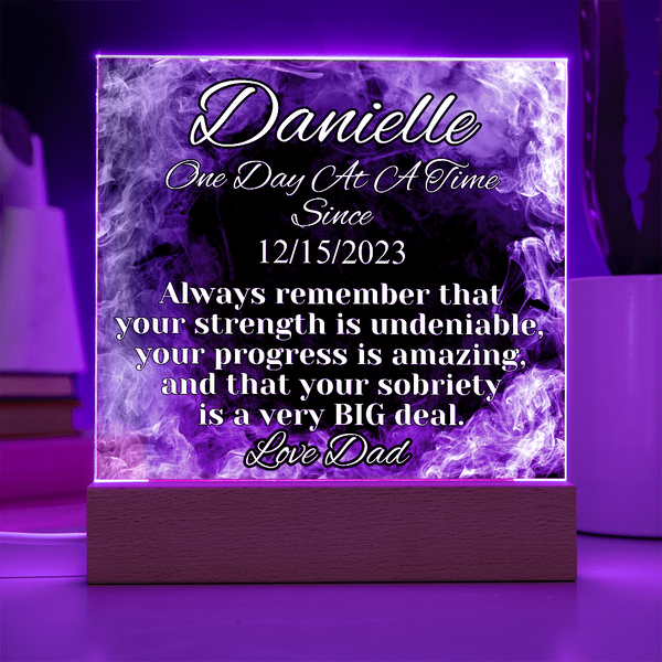 Purple-glowing LED acrylic name plaque on wood base, Danielle text