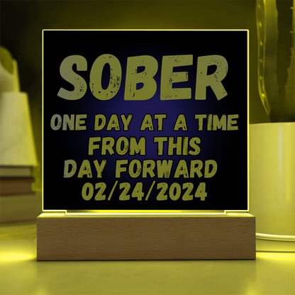 SOBER LED square plaque with yellow-lit border, blue text, and light-wood base