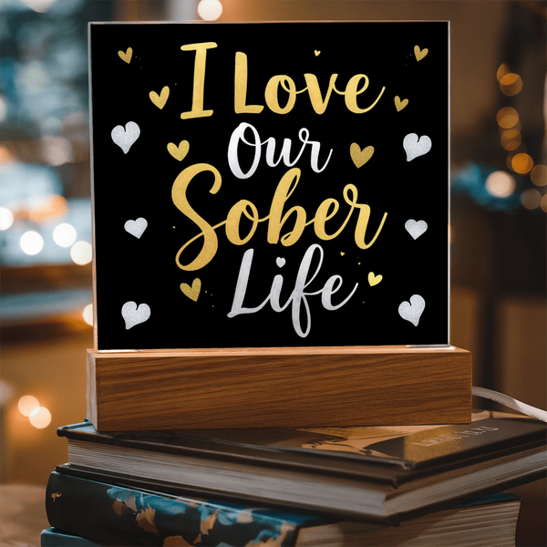 Square LED acrylic plaque with "I Love Our Sober Life" hearts and warm yellow LED border on wood base.