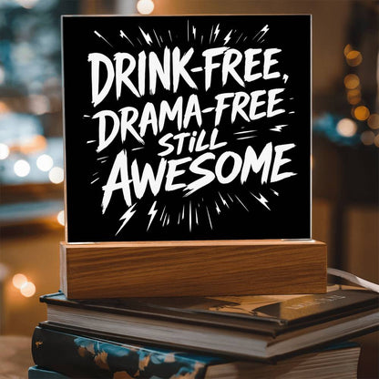 LED plaque with black panel and white slogan DRINK-FREE, DRAMA-FREE, STILL AWESOME on wood base