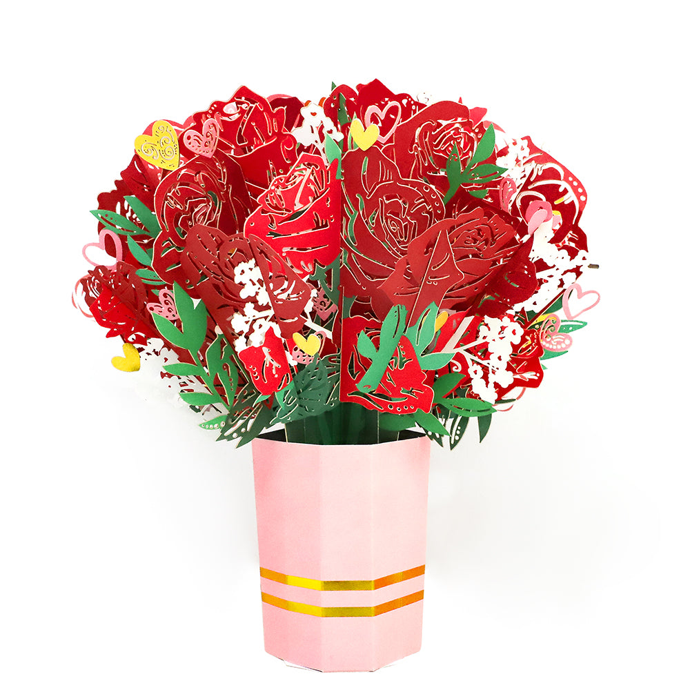 Paper flower bouquet with red roses, green leaves, and pink wrap.