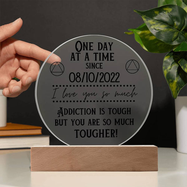 Acrylic circle sobriety plaque on wooden base, showing sober date and encouraging quote