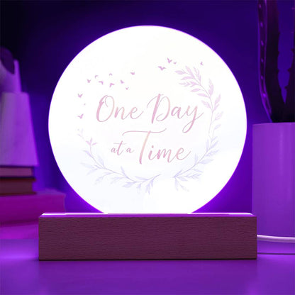Illuminated round acrylic LED plaque reading "One Day at a Time" with floral wreath