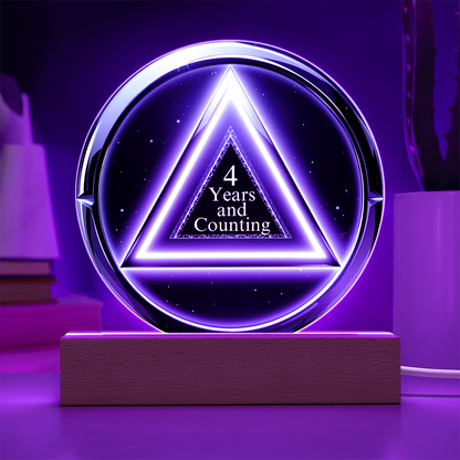 LED circle plaque with “4 Years and Counting” on wood base, purple glow