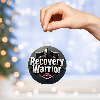 Acrylic Recovery Warrior ornament held by hand, showing helmet graphic and date 11/02/22