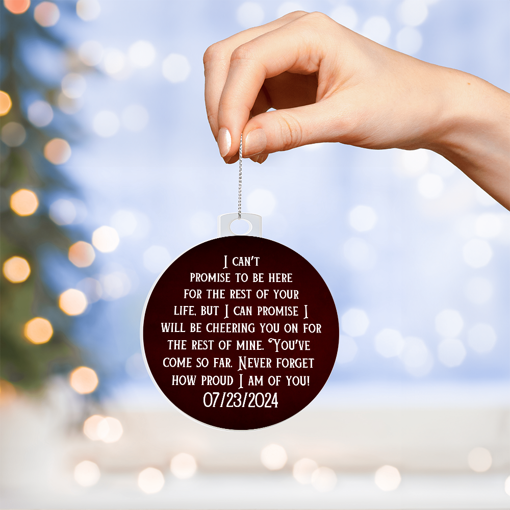 Hand holding maroon acrylic ornament with printed quote and date 07/23/2024 on chain