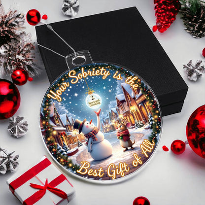 Circular acrylic bulb ornament on black gift box with snowman winter scene and gold border