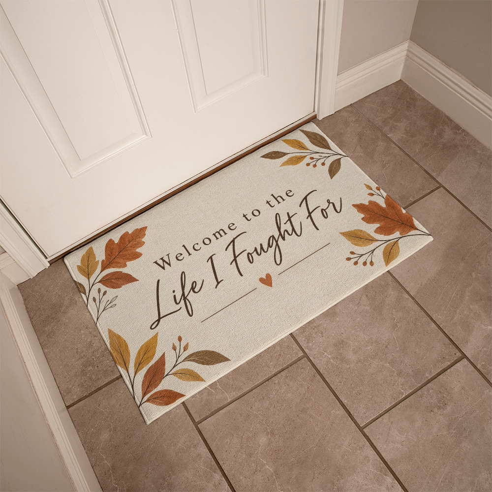 Long beige welcome mat bordered with autumn leaves and centered quote with small heart
