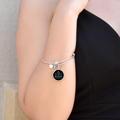 Silver bangle bracelet with round warrior emblem charm worn on wrist