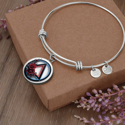 Silver bangle bracelet with round recovery symbol charm and two small engraved tags
