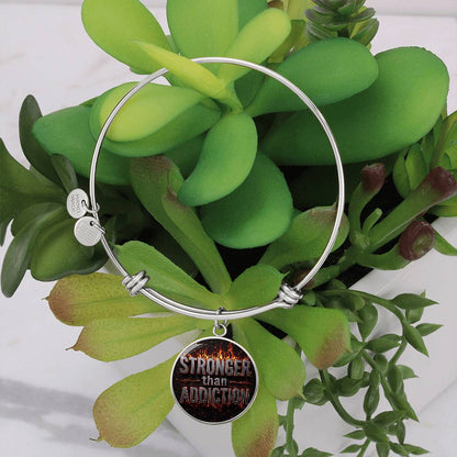 Silver bangle bracelet with round black statement charm and engraved disc details