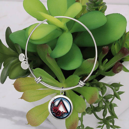 Silver bangle bracelet with round recovery symbol charm and two small engraved tags