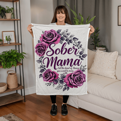 White blanket held up with purple rose wreath and “Sober Mama” lettering at center.