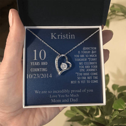 Silver heart pendant necklace in gift box held in hand, with name and 10/23/2014 date