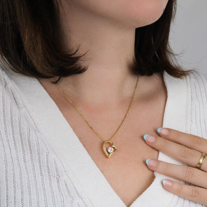 Gold-tone heart pendant necklace on sweater neckline