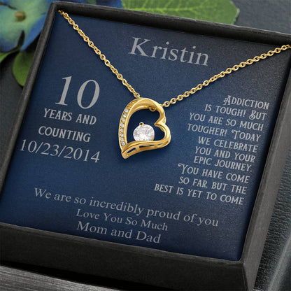 Heart pendant necklace with gold-tone chain on blue gift card with engraved text