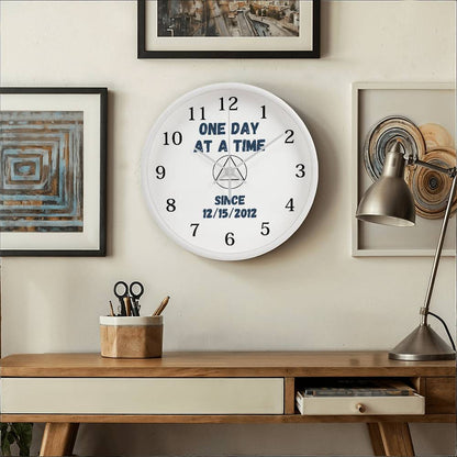 Natural wood wall clock on light wall with black numerals and blue “SINCE 12/15/2012”