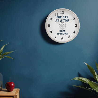 White wall clock with black numerals, blue slogan, and “SINCE 12/15/2012” on face