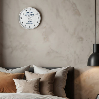Wall clock with white face, black rim, 'ONE DAY AT A TIME' and since date