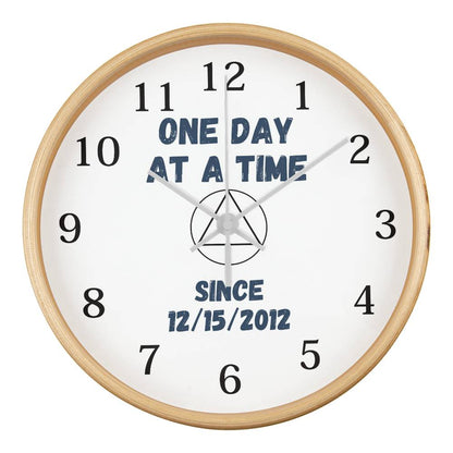 Wall clock with natural wood rim, white face, 'ONE DAY AT A TIME' and since date