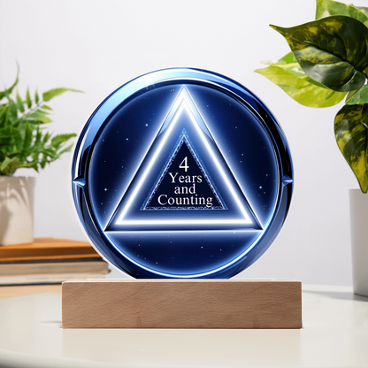 LED circle plaque with “4 Years and Counting” on wood base, blue glow