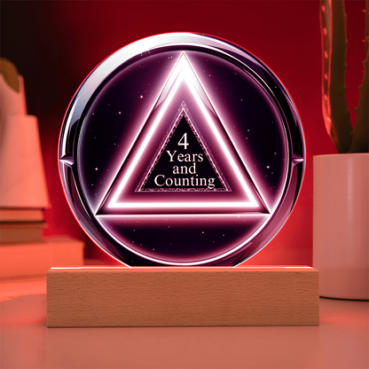 LED circle plaque with “4 Years and Counting” on wood base, red glow